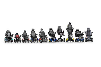 Lineup of various electric wheelchair models in different sizes and configurations, presented side by side on a white background.