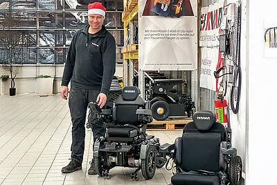 Our employee proudly presents the smallest wheelchair seat we have ever installed at Paravan.