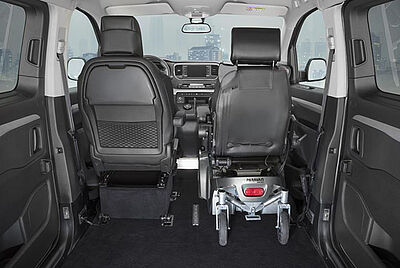 Wheelchair driver position inside a PARAVAN vehicle with spacious interior.