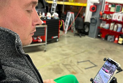 Philip looks seriously at his smartphone, which shows his traffic accident.