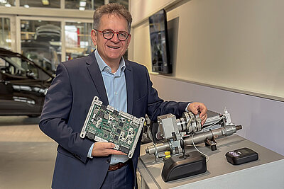 Roland Arnold in a showroom, proudly presenting the electronic components of the Space Drive system.