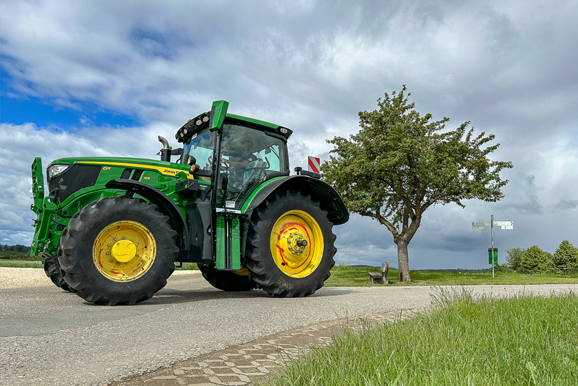 Green John Deere tractor with an individual PARAVAN conversion on a country road.